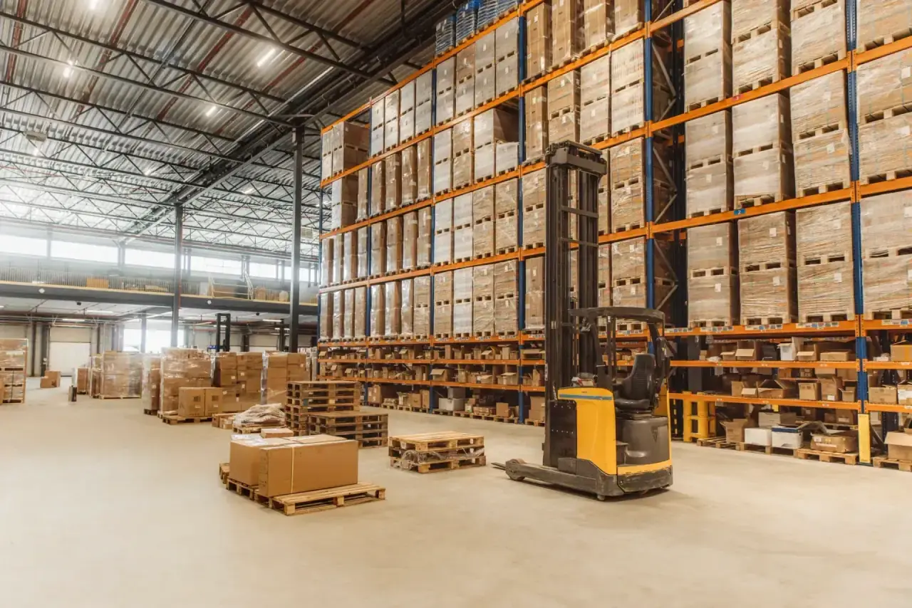 Organised warehouse aisle with high pallet racking and logistics equipment